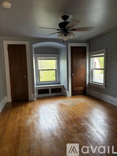 A room with wooden floors and a ceiling fan.