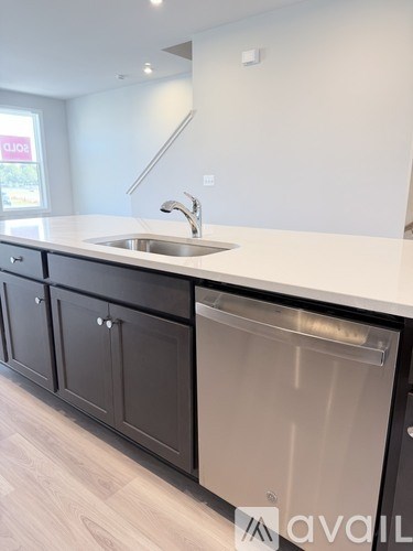 A kitchen with a white counter top and a dishwasher.