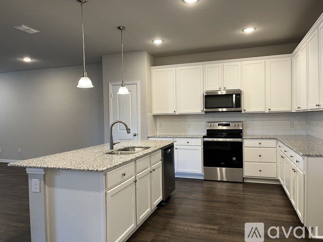A kitchen with white cabinets and a granite countertop.