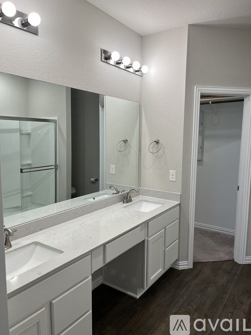 A bathroom with a double sink vanity and a large mirror.
