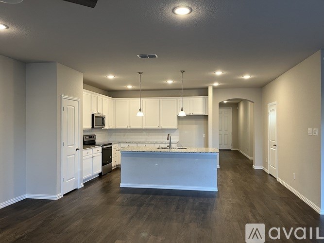 A spacious kitchen with white cabinets and a center island.
