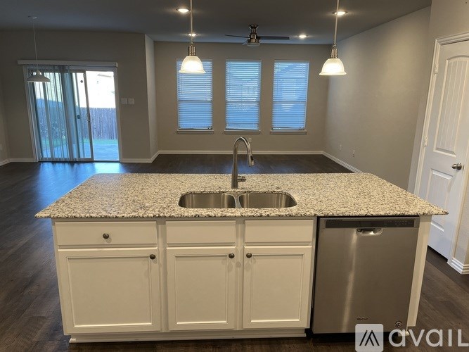 A kitchen with a granite countertop and stainless steel appliances.