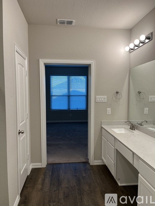 A bathroom with a white sink and a mirror.