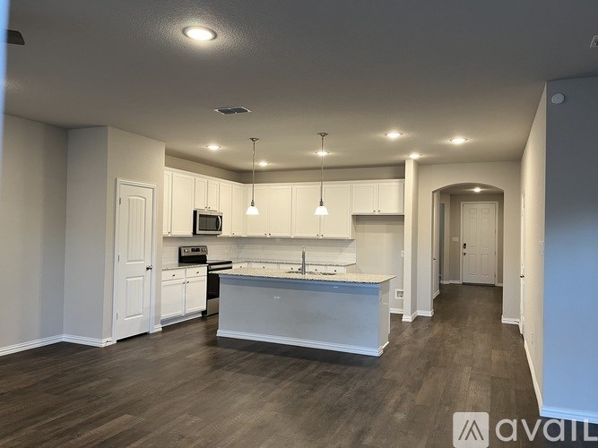 A spacious kitchen with white cabinets and a central island.