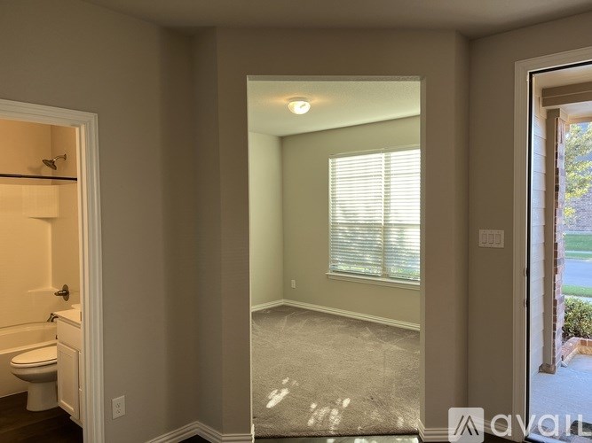 A bathroom with a toilet, sink, and window.
