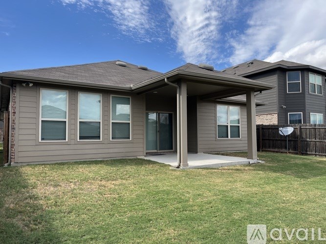 A house with a brown roof and grey walls is available for rent.