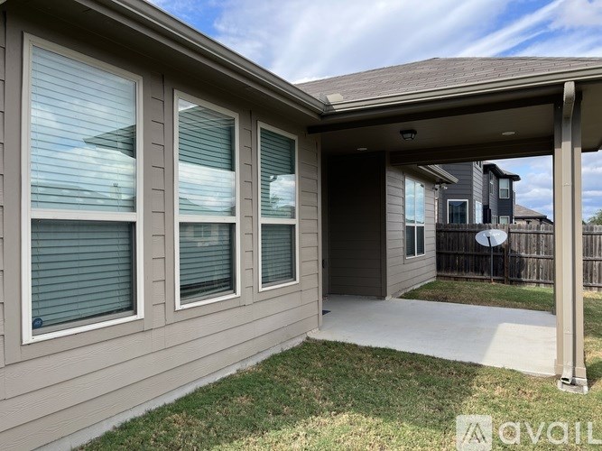 A house with a covered patio and a fence in the background.