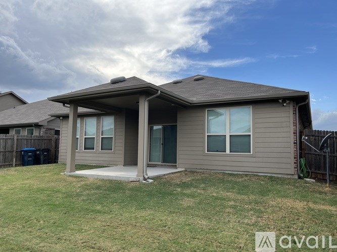A house with a grey siding and a brown roof is available for rent.