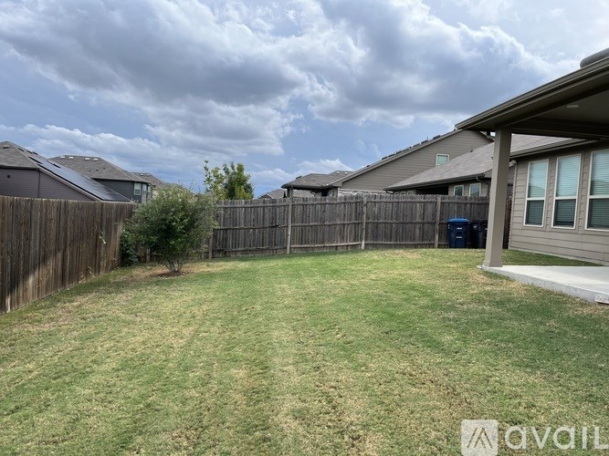 A backyard with a fence and a tree.
