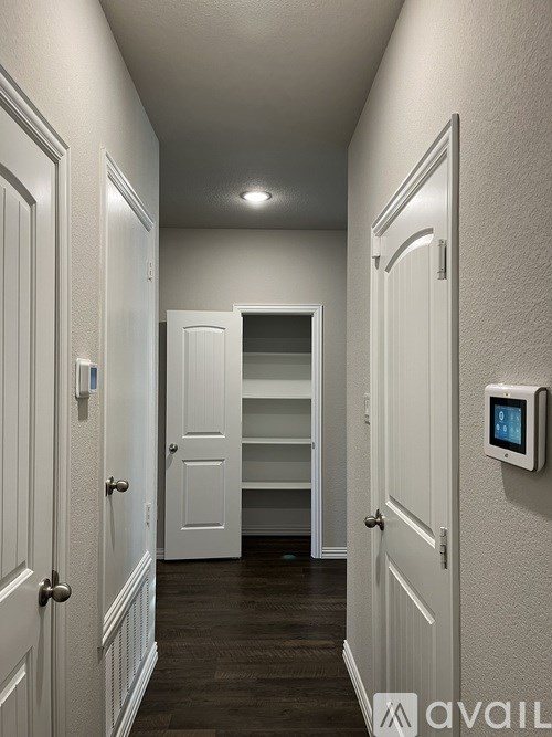 A hallway with a digital display on the wall.