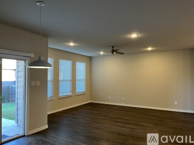 A spacious room with a ceiling fan and sliding glass doors.