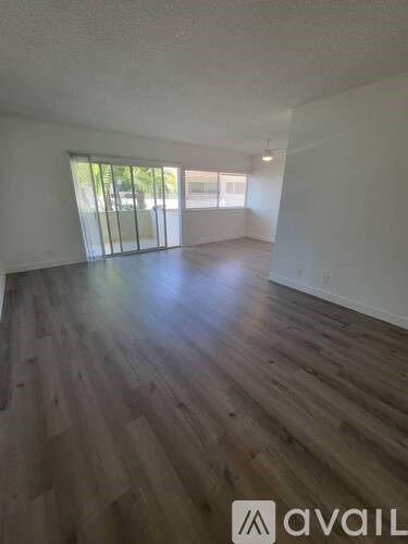 A room with wooden flooring and a large window.