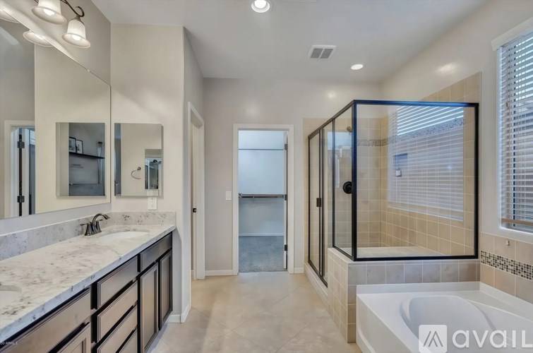 A bathroom with a marble countertop and a walk-in shower.