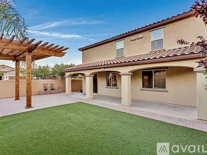 A house with a covered patio area and a green lawn.