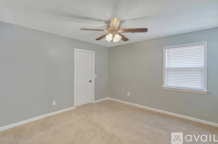 A room with a ceiling fan and a window with blinds.