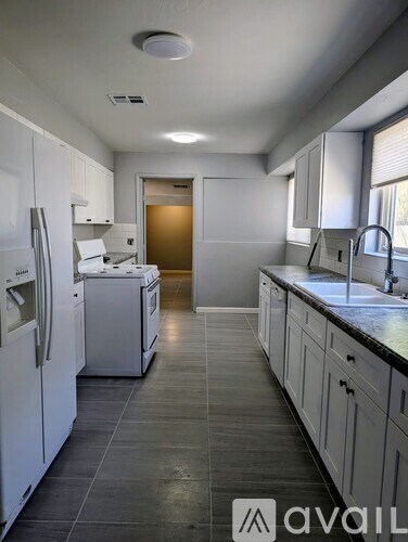 A kitchen with white appliances and cabinets.