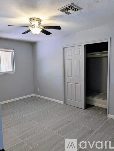 A room with a ceiling fan and a door leading to a bathroom.