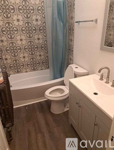 A bathroom with a toilet, sink, and shower curtain.