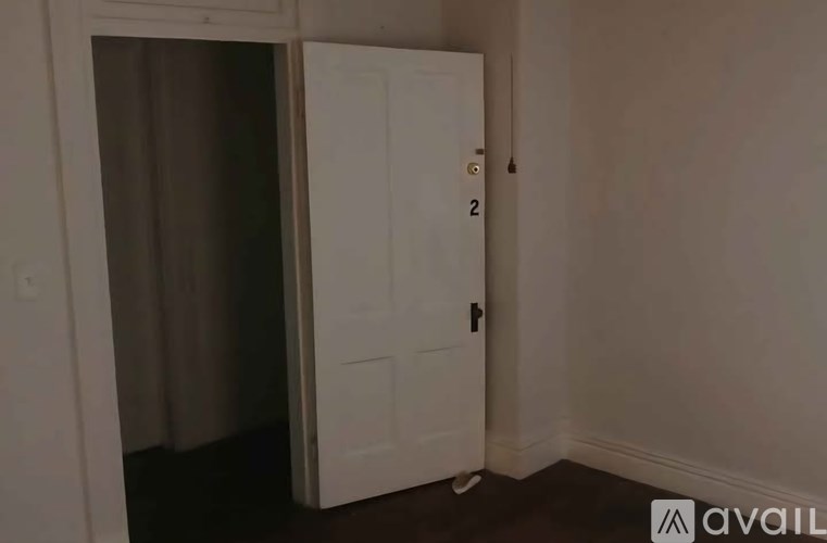 A white door with a number 2 on it is open.