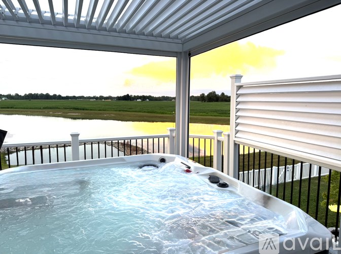 A hot tub on a patio with a view of a lake.
