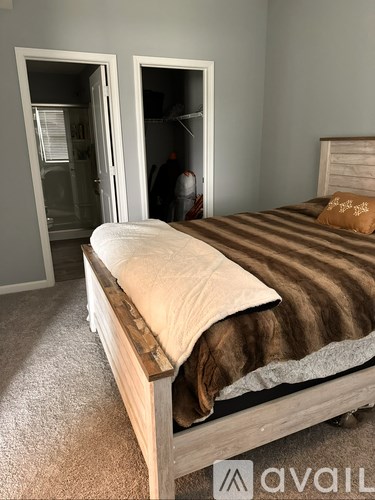 A bedroom with a bed and a carpeted floor.