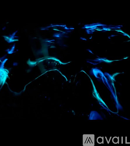 A dark image with blue and green light streaks.