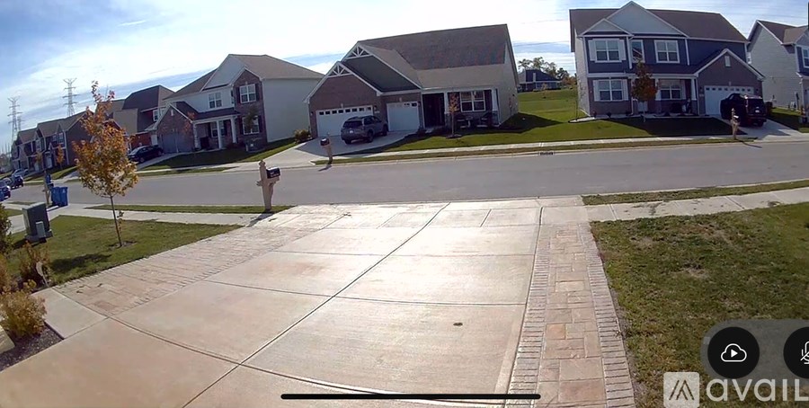 A residential street with houses on both sides and a clear sky.