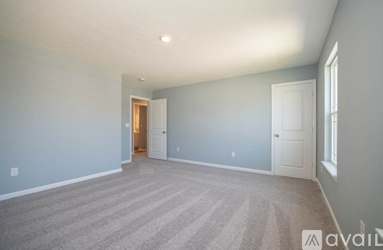A room with a carpeted floor and a doorway leading to another room.