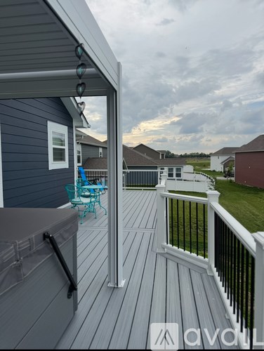 A deck with a white railing and a black handrail.
