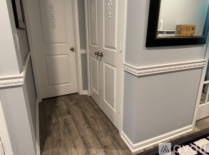 A white door is in a room with a wooden floor.