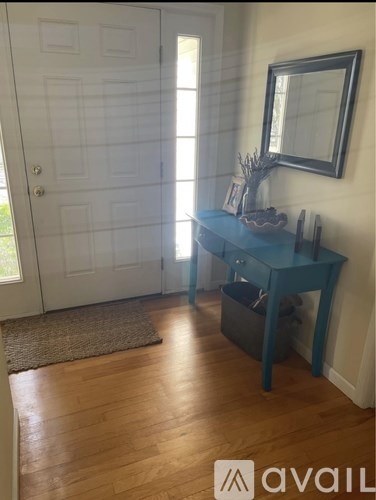 A room with a desk and a mirror on the wall.