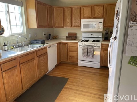 A kitchen with wooden cabinets and a white fridge.