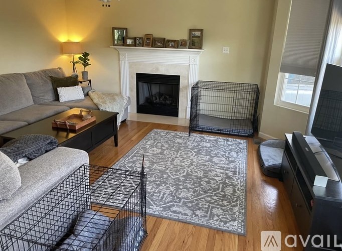 A living room with a grey couch, a black coffee table, and a fireplace.