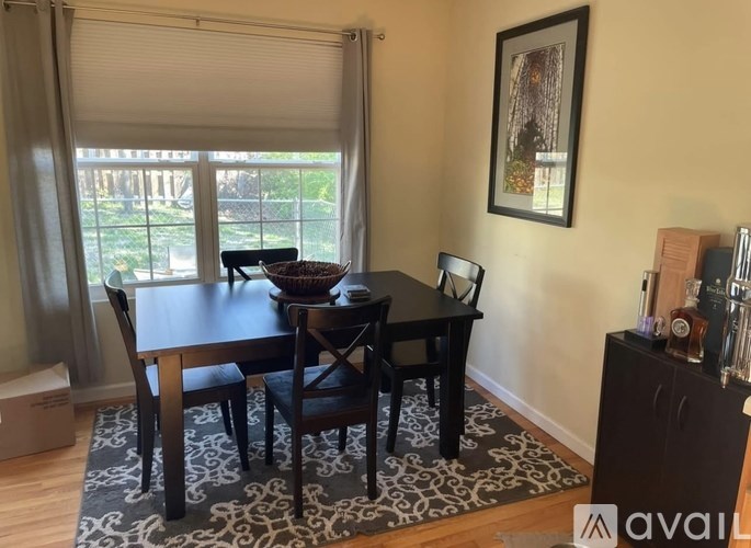 A dining room with a table and chairs.