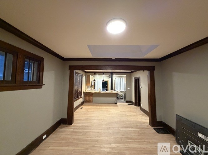A spacious room with wooden floors and a skylight.