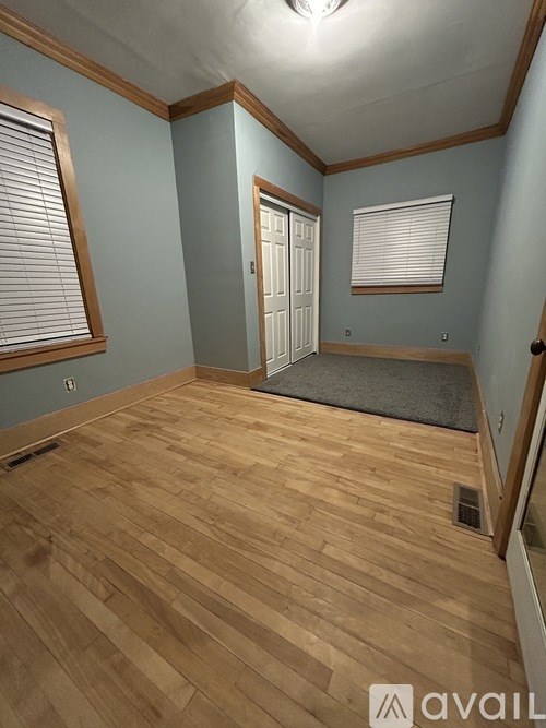 A room with wooden flooring and a door.