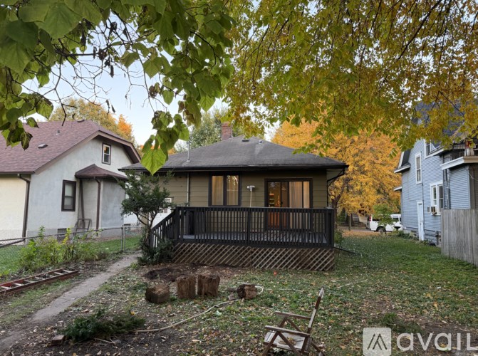 A house with a porch surrounded by trees and a dirt path.