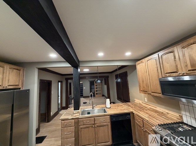 A kitchen with wooden cabinets and a stainless steel refrigerator.