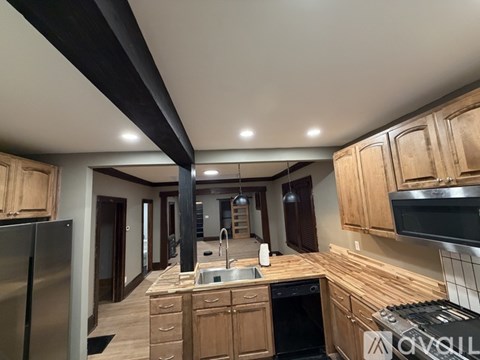 A kitchen with wooden cabinets and a stainless steel refrigerator.