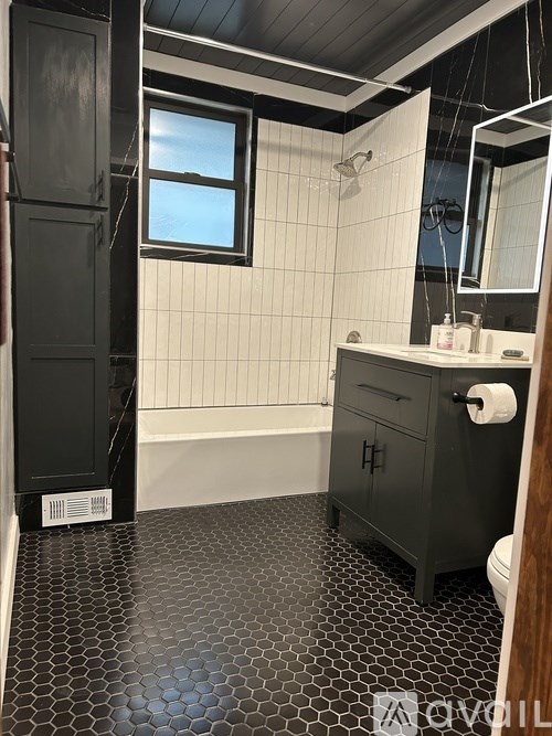 A bathroom with a black and white tiled floor.