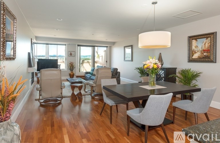 A modern dining room with a wooden table and grey chairs.