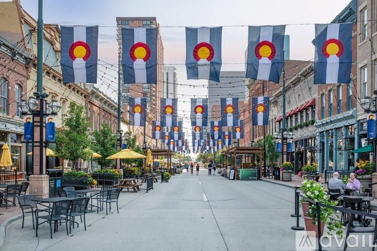 A street lined with tables and chairs under flags.
