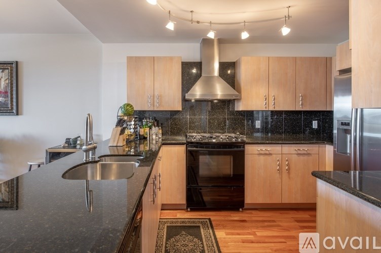 A kitchen with wooden cabinets and a black granite countertop.