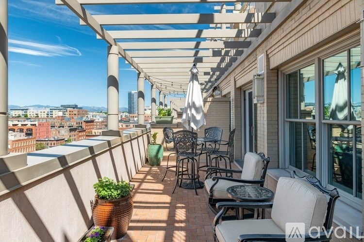 A patio with chairs and tables is covered by a white awning.