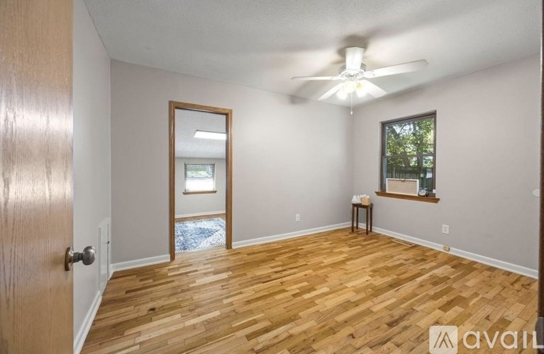 A room with wooden flooring and a ceiling fan.