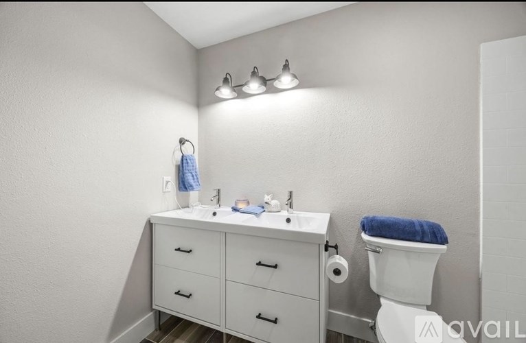 A bathroom with a white sink and a white toilet.