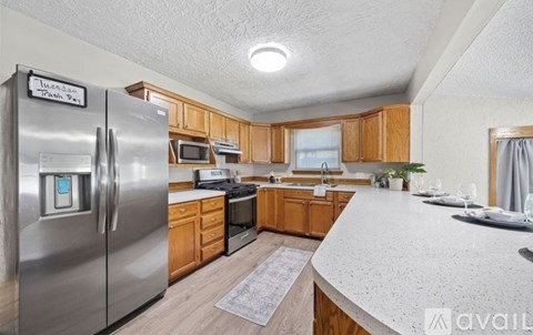 A kitchen with a refrigerator that has a sticker on it that says "Trash Day".