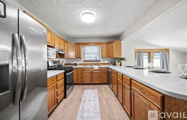 A kitchen with wooden cabinets and a stainless steel refrigerator.