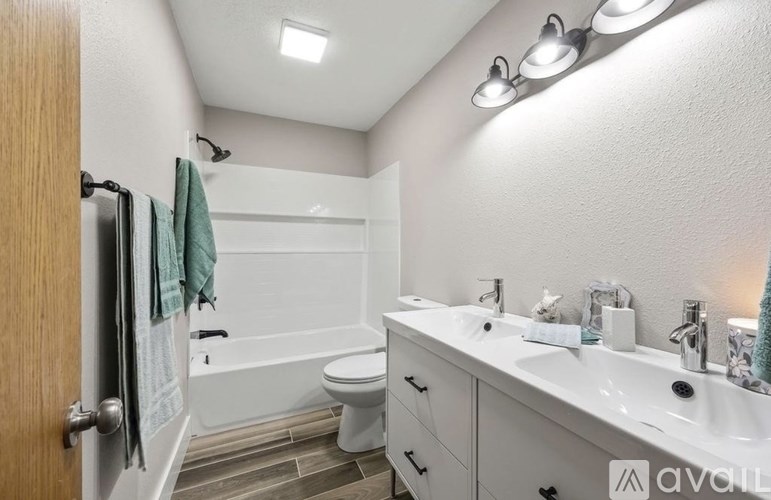 A bathroom with a white tub, toilet, and sink.