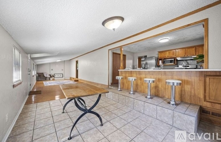 A kitchen with a table and bar stools is available for rent.